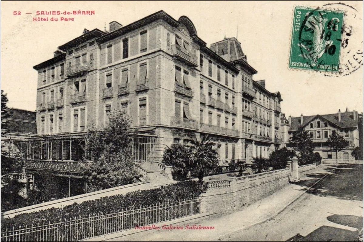 The building, framed by trees and gardens